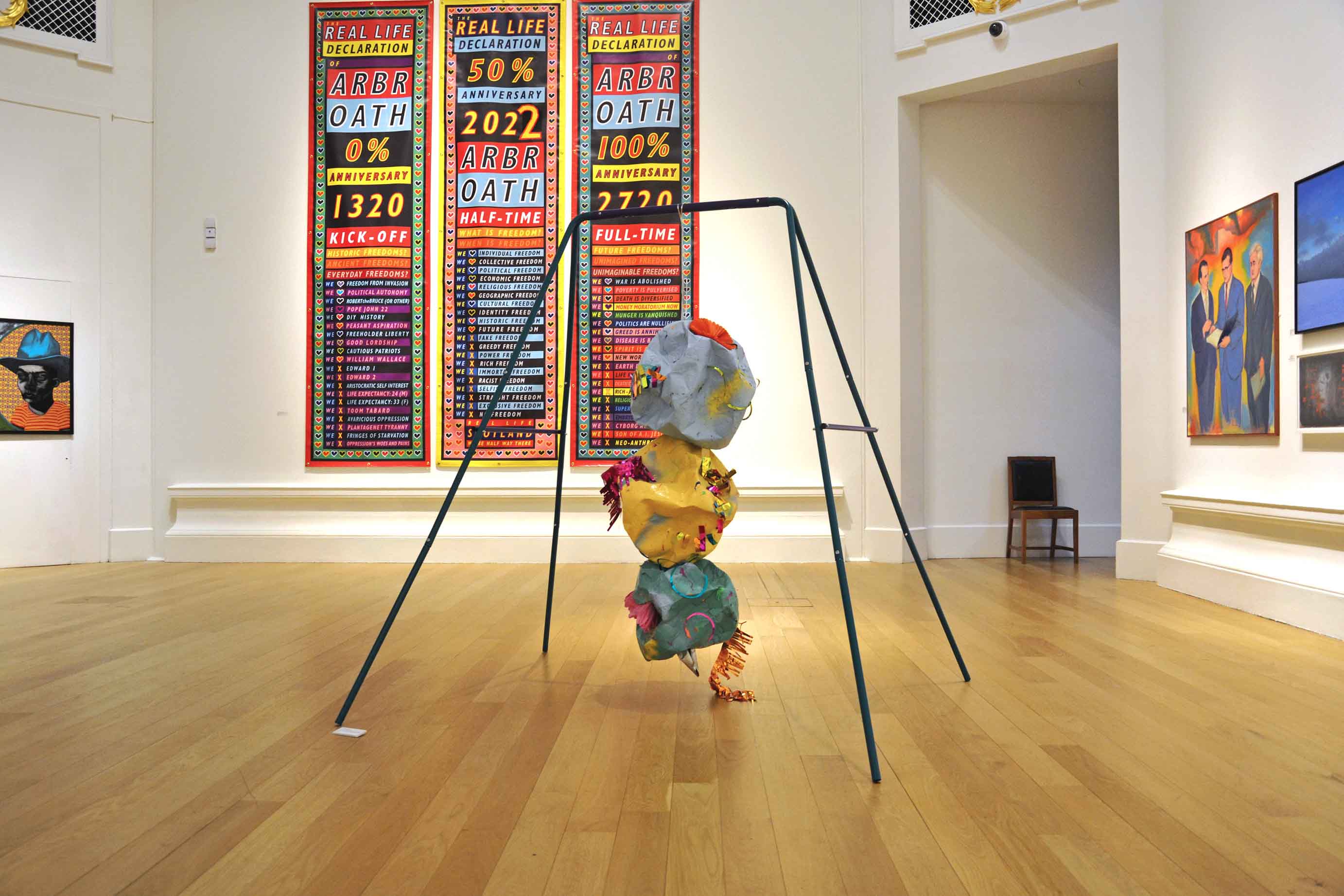 MADE TO WRECK, 2022 : Installed in the 196th Royal Scottish Academy Annual Exhibition - Steel swing set, curling ribbon, spray paint on papier mâché, slime, bouncing putty, party decorations