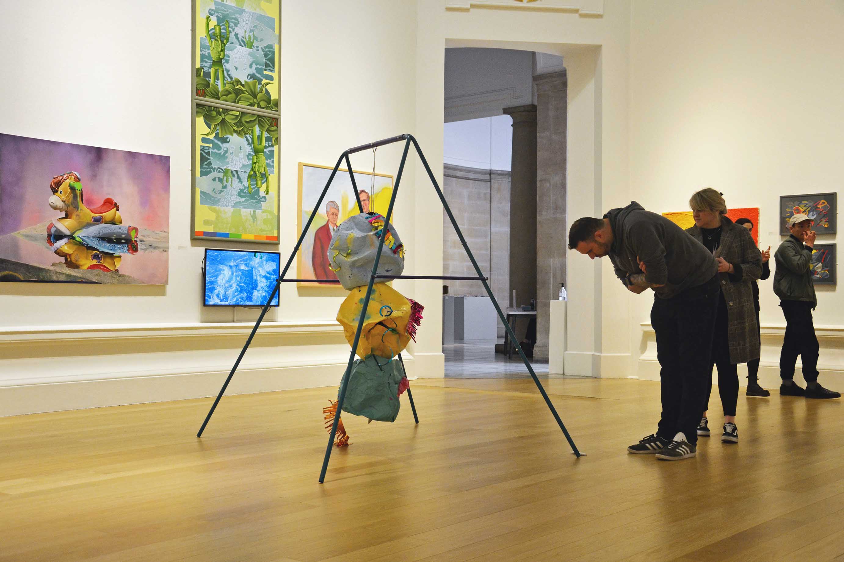 MADE TO WRECK, 2022 : Installed in the 196th Royal Scottish Academy Annual Exhibition - Steel swing set, curling ribbon, spray paint on papier mâché, slime, bouncing putty, party decorations