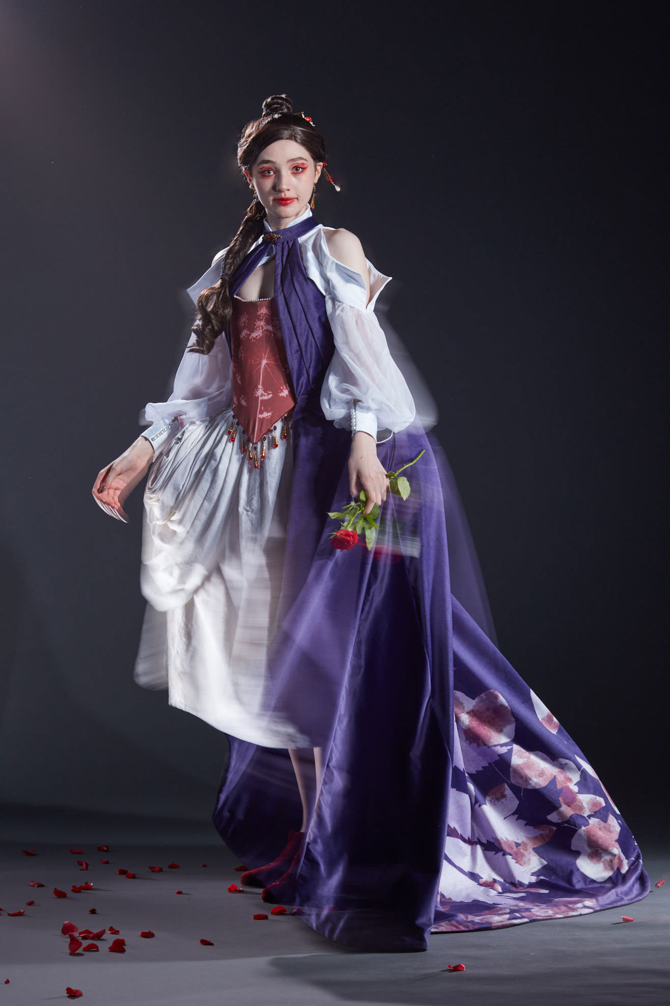 The costume created for the character Lacie from Pandora Hearts. The model wears a purple dress with a red corset, white skirt and sleeves. 