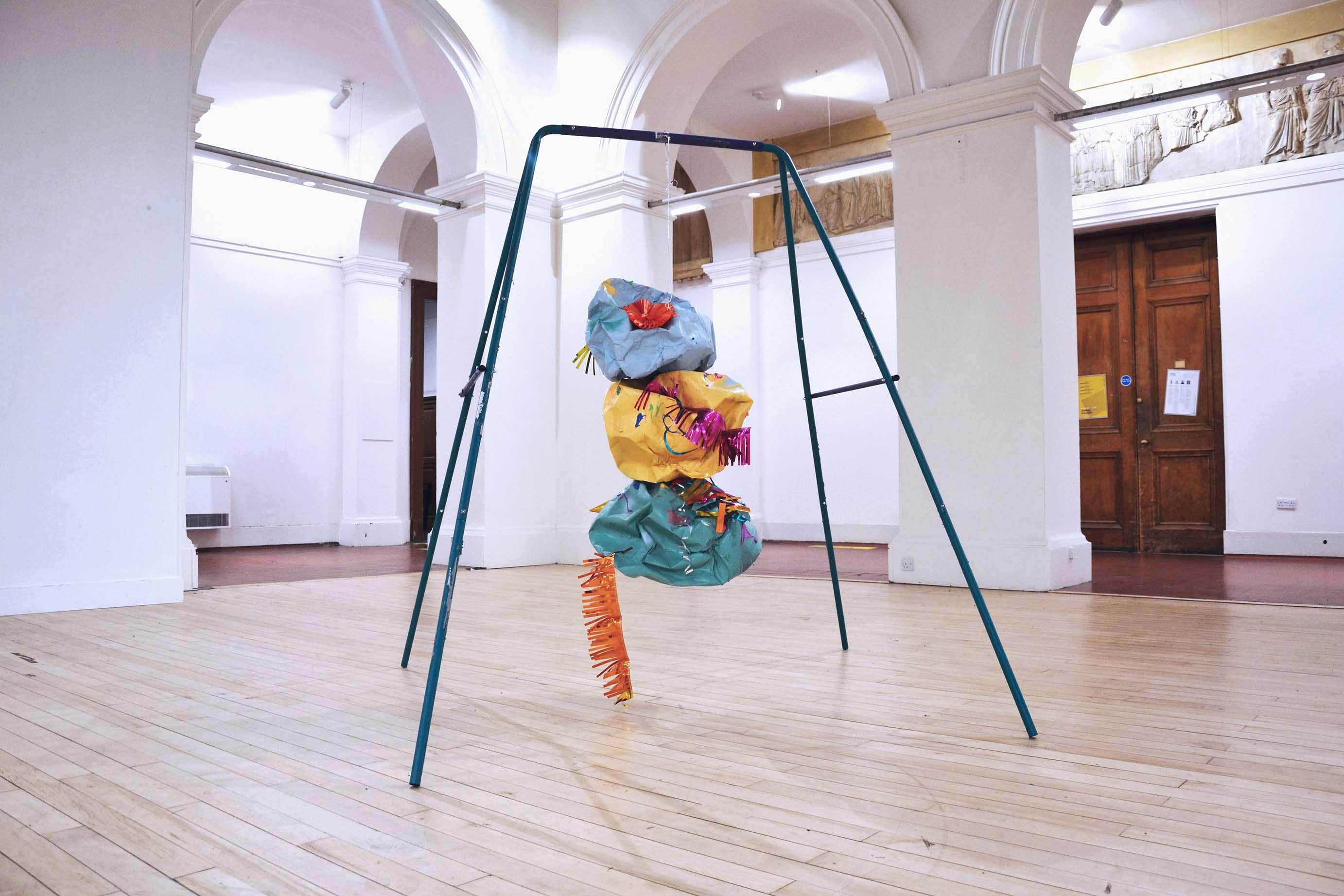 MADE TO WRECK, 2022 - Steel swing set, curling ribbon,  spray paint on papier mâché, slime,  bouncing putty, party decorations