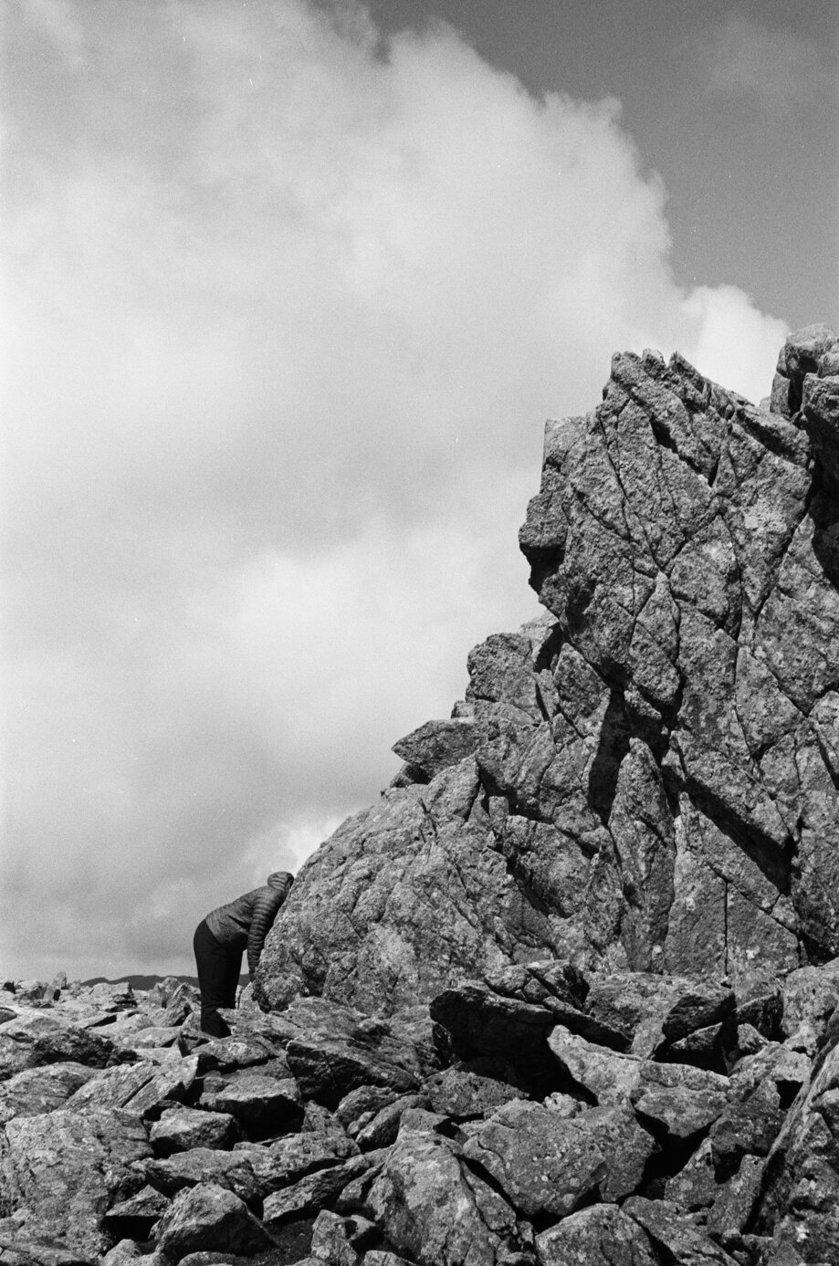 35mm film photograph of a body leaning into rocks