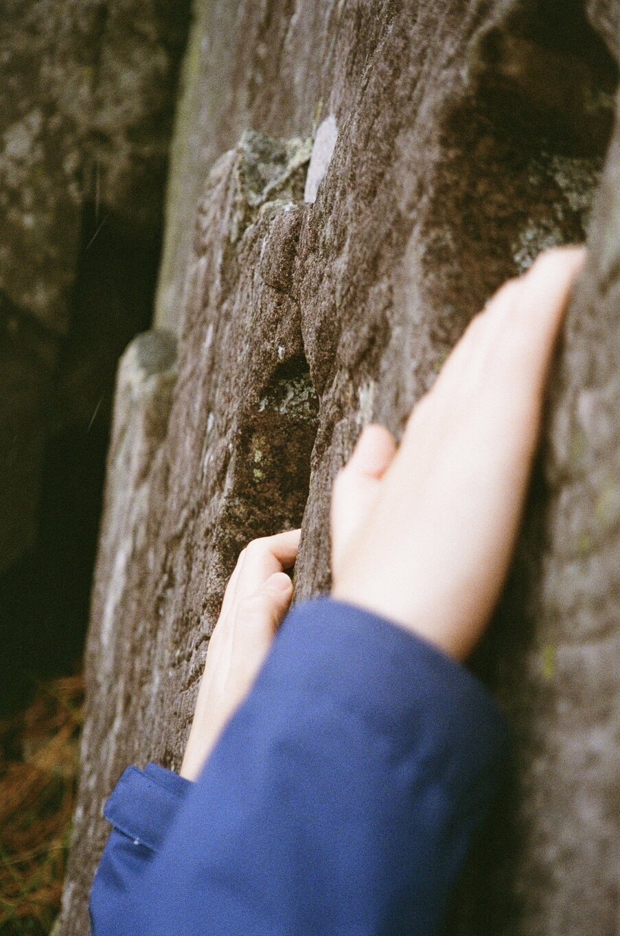 Hands holding on to rock edge